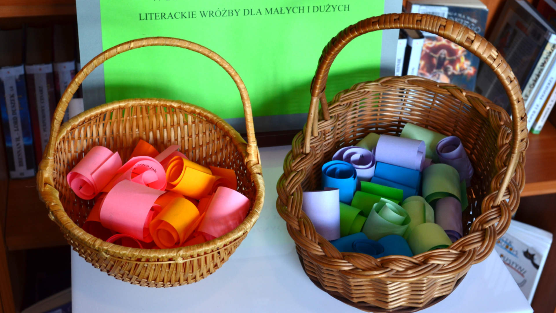 Zdjęcie koszyków z kolorowymi rulonikami papieru, na którym zapisane są literackie wróżby.